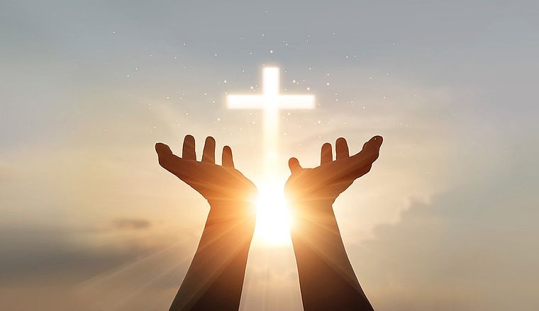 Zwei Hände zeigen in den Himmel – sie symbolisieren die Kirche als Arbeitgeber