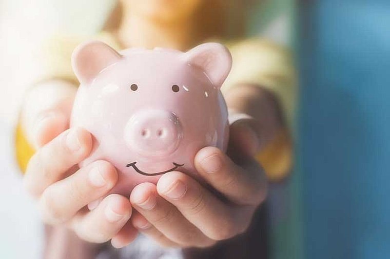 Ein Kind hält sein Sparschwein- für es gilt der Taschengeldparagraph